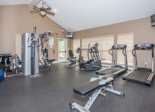 The fitness center with treadmills and weight machines at Preston Court Apartment Homes in Overland Park, Kansas.