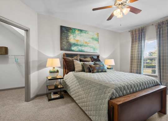 a bedroom with a bed and a ceiling fan at Stonepost Crossing Apartments, Overland Park, Kansas