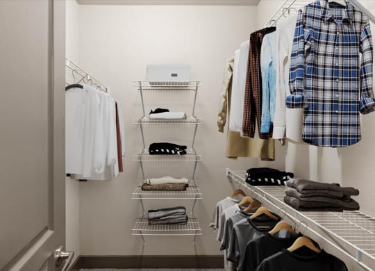 a walk in closet with white shelves and a white door