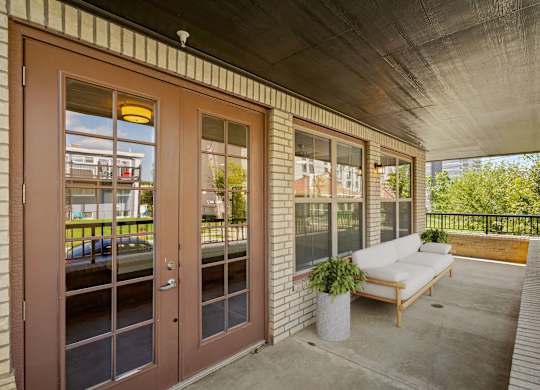 the porch of a building with a couch and a chair on it at The Dorset, Kansas City, 64112