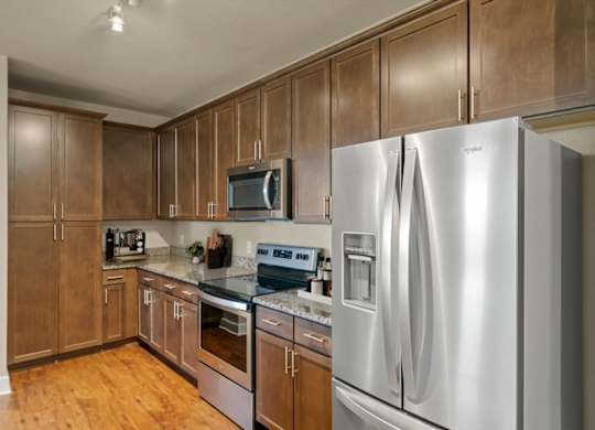Kitchen with stainless steel refrigerator at The Residences at Bluhawk Apartments, Kansas, 66085