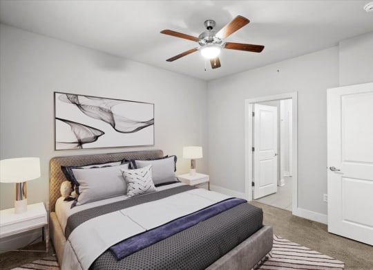 a bedroom with a double bed, white walls and a ceiling fan