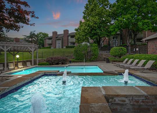 A pool with a fountain in the middle of it.