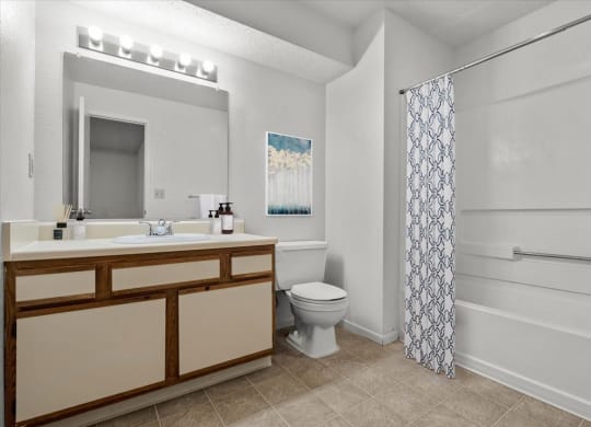 a bathroom with a toilet and a sink and a showerat Millcreek Woods Apartments, Olathe, 66061