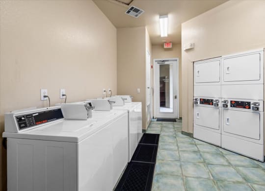 a laundry room with four washers and two dryers