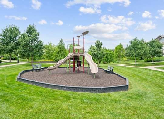 A playground with a slide and a red pole.