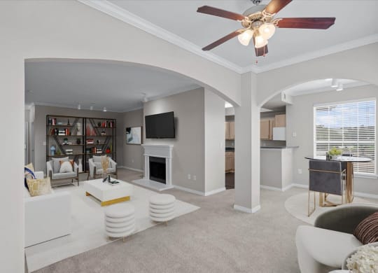 a living room with a fireplace and a ceiling fan at The Clairborne Apartment Homes, Texas