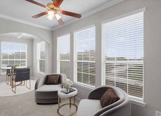 a living room with four windows and a ceiling fan at The Clairborne Apartment Homes, Grand Prairie, TX, 75050