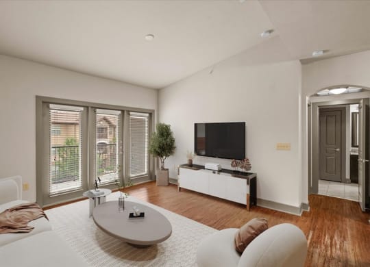 a living room with a white couch and a tv on the wall
