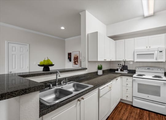 a kitchen with white cabinets and a granite counter top
