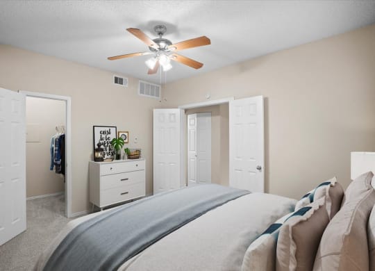 a bedroom with a large bed and a ceiling fan at Creekview Apartment Homes, Dallas, 75254