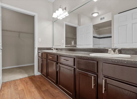 a bathroom with a sink and a mirror at The Clairborne Apartment Homes, Grand Prairie, TX