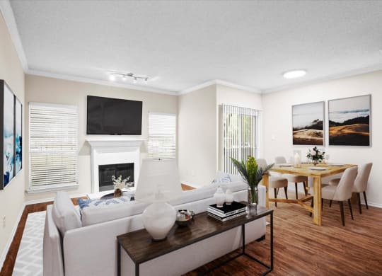 a living room with a fireplace and a dining room in the background at Creekview Apartment Homes, Texas