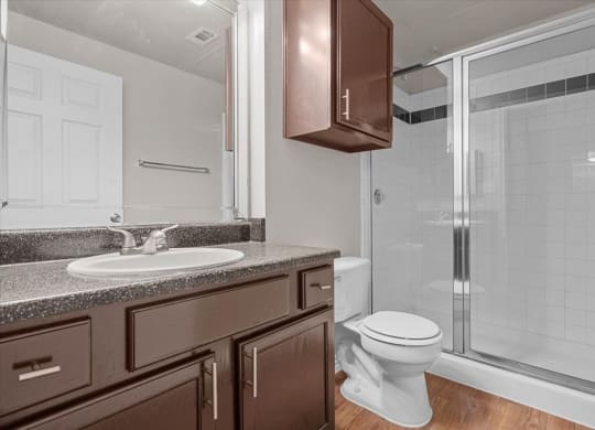 a bathroom with a toilet sink and shower at The Clairborne Apartment Homes, Grand Prairie
