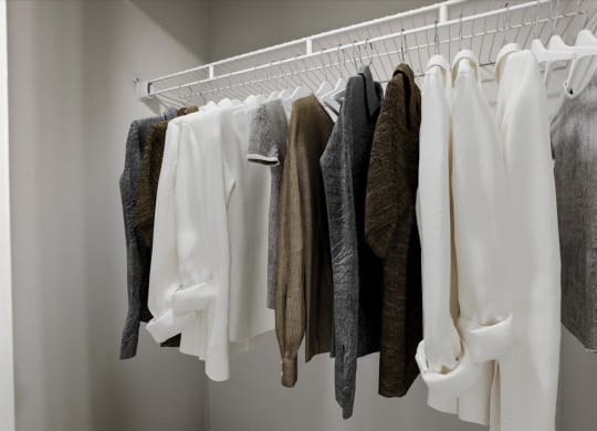 a wardrobe with white clothes and a white hanger at Creekview Apartment Homes, Texas