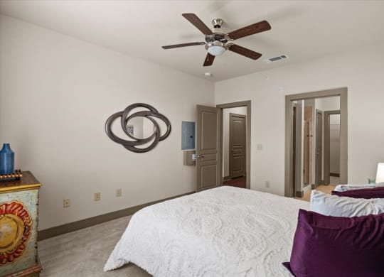 a bedroom with a large bed and a ceiling fan