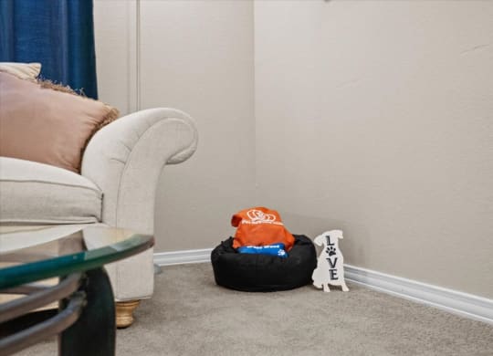 a living room filled with furniture and a white chair at The Clairborne Apartment Homes, Grand Prairie, Texas