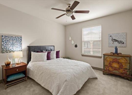 a bedroom with a bed and a ceiling fan