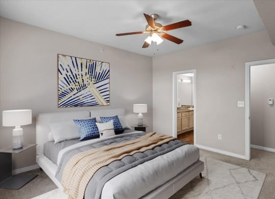 a bedroom with a large bed and a ceiling fan at The Clairborne Apartment Homes, Grand Prairie