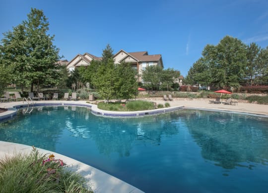 A beautiful, large lagoon pool with a sand beach entrance and lush landscaping.
