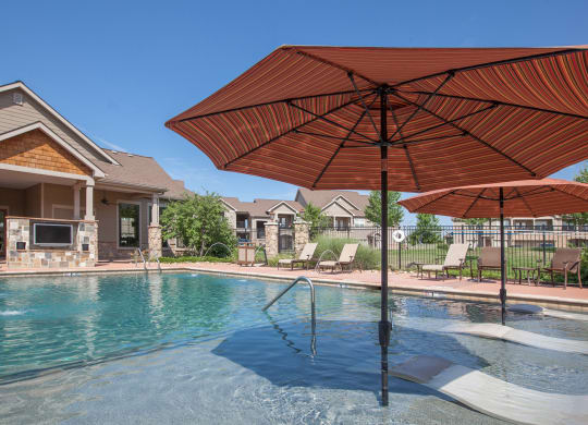 Shaded lounge seating and an outdoor TV at the cabana pool at Stonepost Ranch.