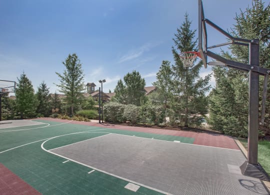A full size basketball court with trees at Stonepost Ranch Apartments in Overland Park, Kansas.