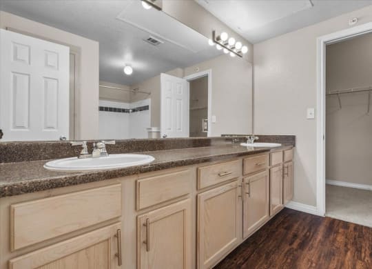 a bathroom with a sink and a mirror at The Clairborne Apartment Homes, Grand Prairie