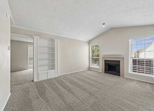 A living room with a fireplace and a window with blinds.
