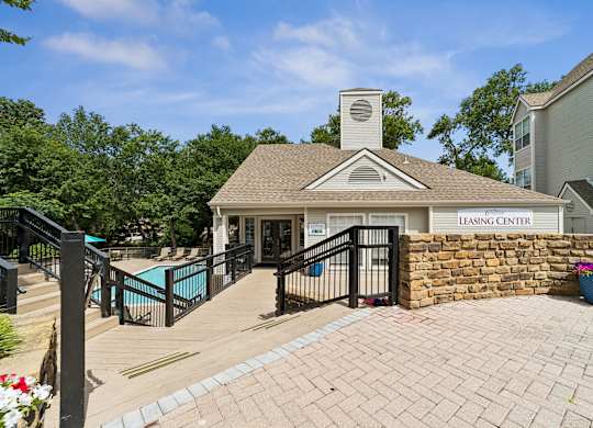 A leasing center with a pool and a brick wall.