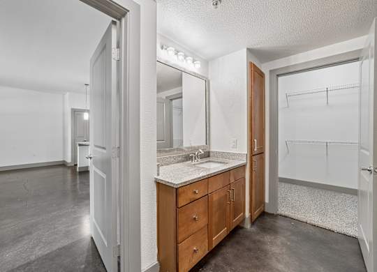 A bathroom with a sink, mirror, and wooden cabinets.