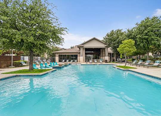 A large swimming pool with a building in the background.