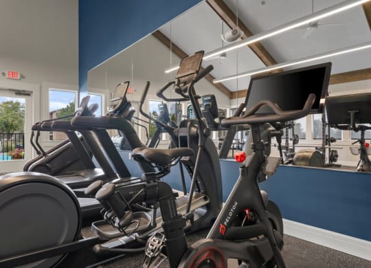 a gym with various exercise bikes and a monitor