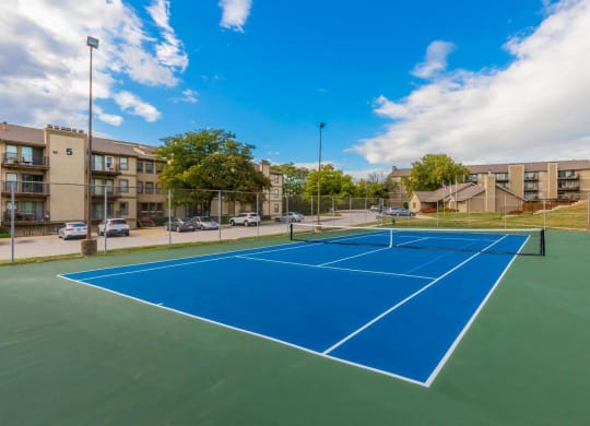 a pickleball court with apartments in the background