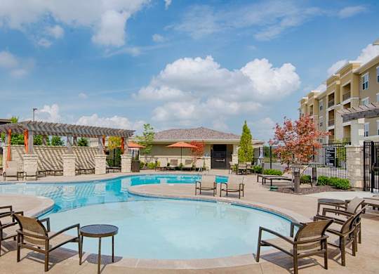 A large outdoor swimming pool surrounded by chairs and tables at Residences at Prairiefire Apartment Homes, Kansas, 66223