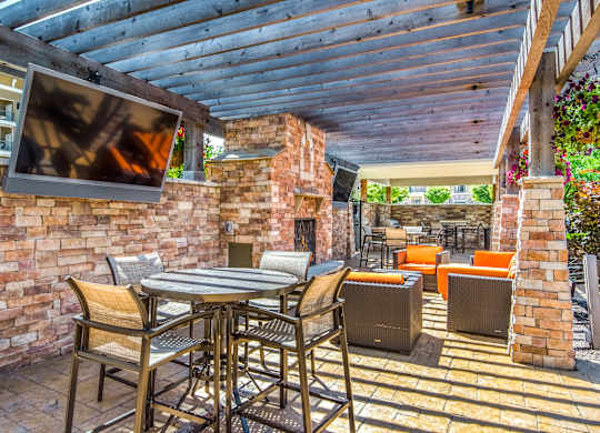 A patio with a table and chairs under a roof. at Residences at Prairiefire Apartment Homes, Overland Park, Kansas
