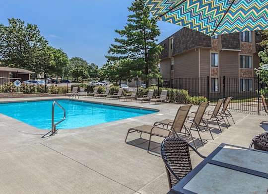 Swimming pool with lounge seating at Bristol Pointe Apartments in Olathe, Kansas.