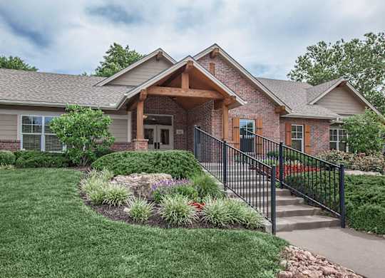 The leasing office & clubhouse with pretty landscaping at Preston Court Apartments in Overland Park, KS.