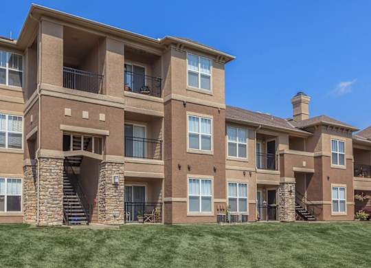 The exterior of apartment buildings overlooking a green lawn.