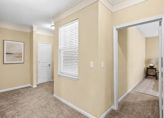 A room with a white door and a window with blinds.
