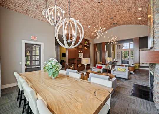 A large wooden table with chairs and a vase of flowers is the focal point of this room.