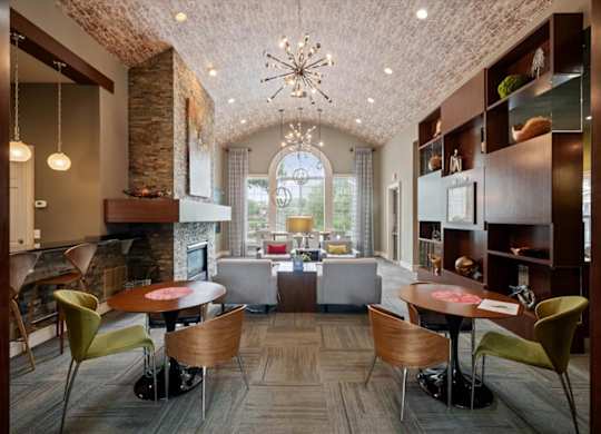 A large room with a fireplace and a dining table with chairs.
