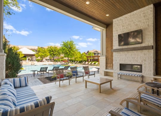 the outdoor living area has a fireplace and a swimming pool