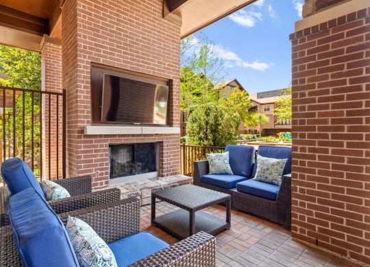 a patio with a brick fireplace and furniture