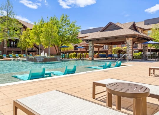a swimming pool with lounge chairs and a table