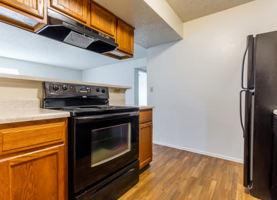 Black appliances and wooden cabinets1 at Coventry Oaks Apartments, Overland Park, KS