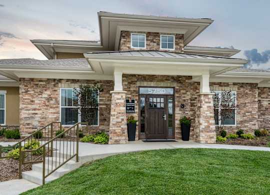 A modern house with a stone facade and a wooden door. at Residences at Prairiefire Apartment Homes, Overland Park