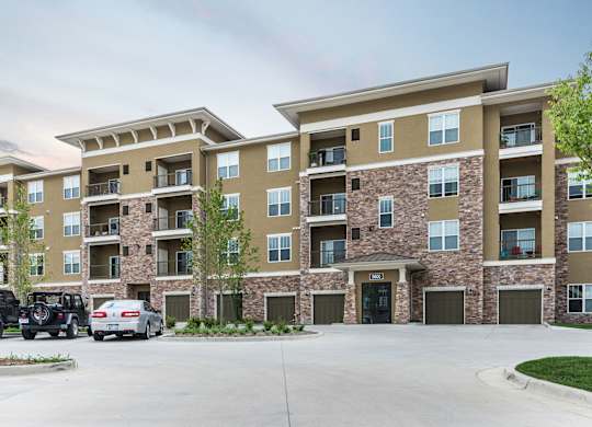 A large apartment complex with a parking lot in front. at Residences at Prairiefire Apartment Homes, Overland Park, KS