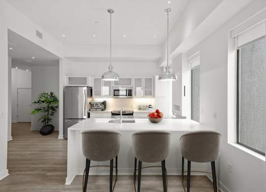 A modern kitchen with a dining table and chairs.