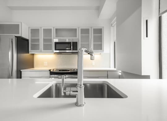 A modern kitchen with a stainless steel refrigerator and a white countertop.