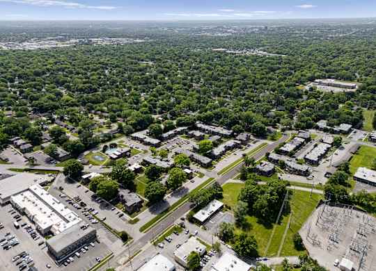 Aerial view of Louisburg Square Apartments and townhomes surrounded by tree-lined streets in Overland Park, KS.